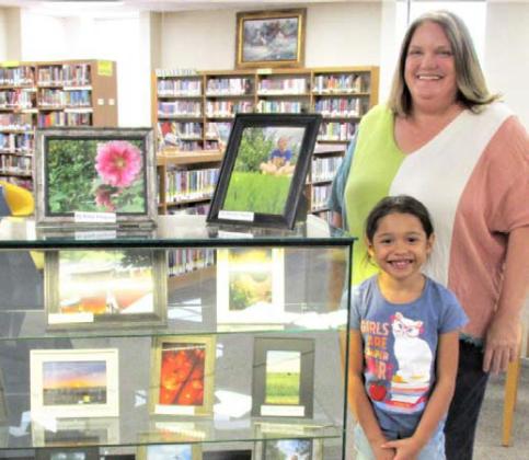 The August Display of the Month at Rhoads Memorial Library features Castro County 4-H photos. Felice Acker, Castro County AgriLife Extension agent heads up the project and helper Karen Grado.