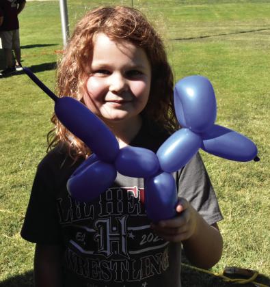 LIKE MY NEW DOG? Ava Powell, 8, shows off the balloon version of a wienie dog, replete with looping ears and a tail, that she was presented with during the Hereford Jubilee Saturday August 15. (Photo by Jim Steiert)