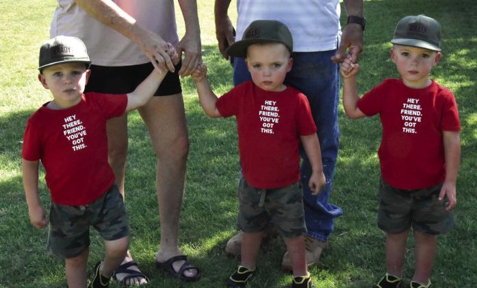TRIPLE TRACTOR THREAT--Grady, Well and Miller Blair brought their grandparents to the Hereford Jubilee August 15 specifically to prove their prowess at climbing on antique tractors--which just happened to be on hand at the local event. The triplet boys are just shy of three years old. (Photo by Jim Steiert)