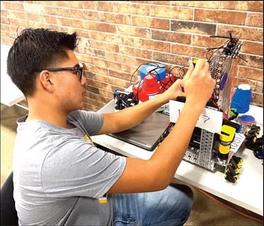 Nazareth Robotics rookie Aiden Chea works on fine tuning the robot before the scrimmage competition at Amarillo this past weekend.