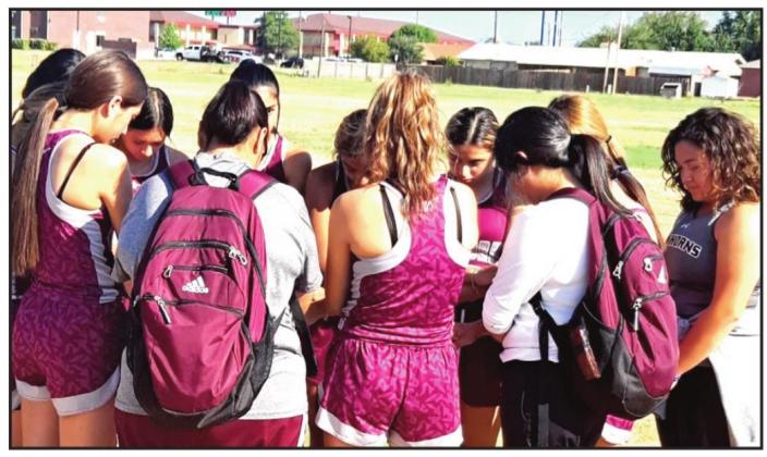 Hart varsity and JV girls join in a prayer before the Plainview XC meet got underway on Saturday.