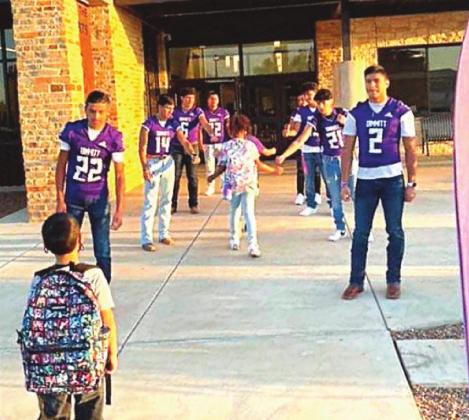 Dimmitt football players took time out to greet students at Richardson Elementary on their way to class.
