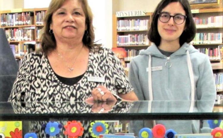 Sulema Oltivero (left), and Paola Alonzo created the display for the months of June and July at Rhoads Memorial Library. Featuring the summer reading program.