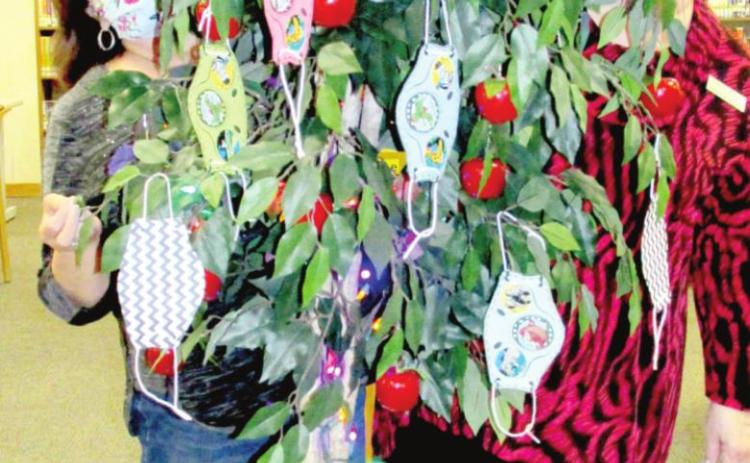 No, it's not Santa's helpers - it's librarians Sulema Oltivero (left) and Gaye Reily (right) peeking out from a Pandemic 2020 Tree.