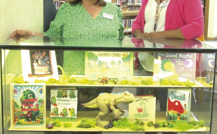 The theme of 'Unearth a Story' is featured as the Display for the months of June and July, 2026, at Rhoads Memorial Library. Sulema Oltivero, left, and Rosa Medina, library personnel, created the display to remind youngsters of the summer reading program that uses that theme.