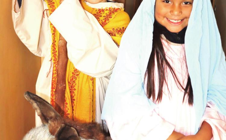 Traveling of Census — Crew Clark, left, and Jaselyn Gonzalez take on the attire of Joseph and Mary and pose with a prop donkey as they anticipate the upcoming “Walk Through Bethlehem” and a celebration of Las Posadas on Sunday, Dec. 5 at Saint Anthony School in Hereford.