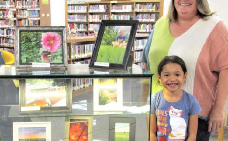 The August Display of the Month at Rhoads Memorial Library features Castro County 4-H photos. Felice Acker, Castro County AgriLife Extension agent heads up the project and helper Karen Grado.