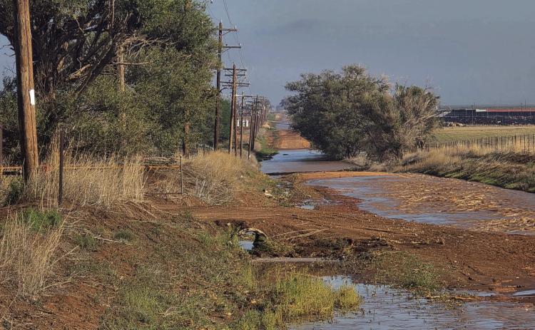 WEST 15TH WASHED OUTHeavy rains in and around Hereford left water gushing down county roads that had no drainage ditches to carry the load. The aftermath of heavy washing on West 15th near a Deaf Smith Electric Cooperative substation is evident here.
