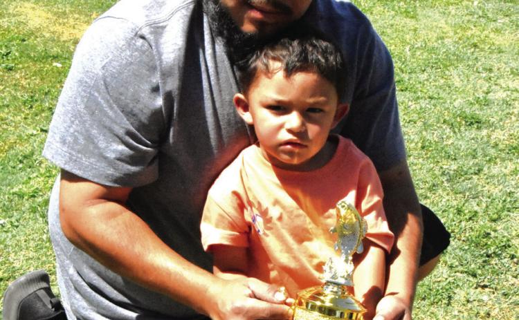 A LITTLE HELP FROM DAD—Jai Gonzalez, 3, shows off a pair of nice channel catfish caught at the Texas Junior angler event Saturday, May 16 at Josserand Aquatic Park Pond, with a steady hand from Dad, Jaden, on the stringer. (Photo by Jim Steiert)