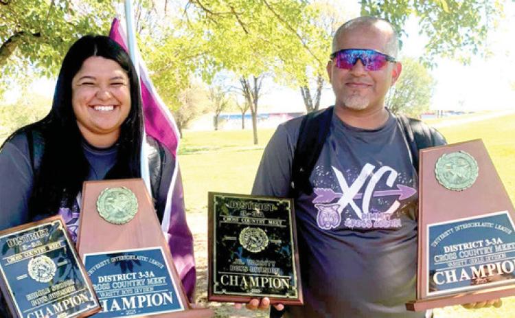 With big team wins at the district cross country meet, DHS/ DMS assistant coach Haley Bonila and head coach Jason Ayala show off the first-place plaques earned by theDHS varsity girls and boys, DHS JV boys, and DMS boys.