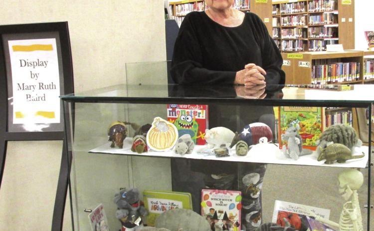 Mary Ruth Baird is shown with her collection of stuffed armadillos, who are masked and ready for Halloween at Rhoads Memorial Library. The October display of the month also features Stuart Skeleton reading spine-tingling tales to them and visiting ghosts.