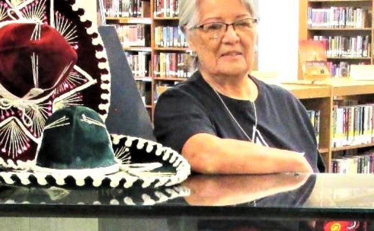 September’s Display of the Month at Rhoads Memorial Library, shown with Gloria Hernandez, features items pertaining to Hispanic heritage.