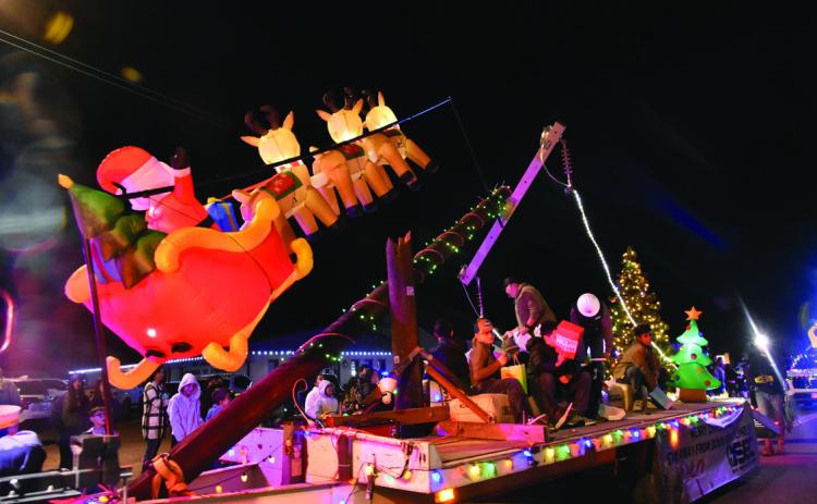 POWER LINE FLYOVER—Santa and his reindeer make a low pass warning all to be safe around downed power lines in this Deaf Smith Electric Cooperative float that won Best Lighted in the Lighted Christmas Parade December 8. The Cooperative had multiple lighted vehicles in the parade. (Photo by Jim Steiert)