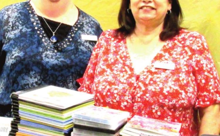 Rhoads Memorial Library Director Gaye Reily, left, and Assistant Director Sulema Oltivero sort through 237 new books and 40 DVDs purchased via two grants totaling $3,750 for the Juvenile section. The items arrive in time for the Summer Reading program that starts on June 1.
