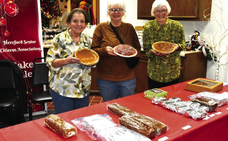 BAKE SALE STALWARTS--The baked goods and home made candy sale at the Festival of Trees is a sure draw every years. Chances are, if you have browsed and patronized the sale, you have encountered this trio of ladies who handle display, sale, and baking duties. From left are Terry Rhyne, Carla Rampley, and Irma Murphey styling pies. (Photo by Jim Steiert)